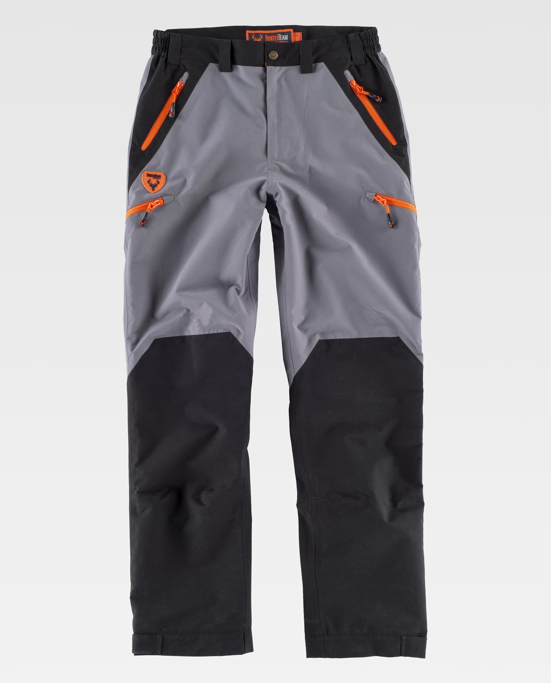 Pantalón técnico de trekking gris y negro con cremalleras naranjas y varios bolsillos delanteros