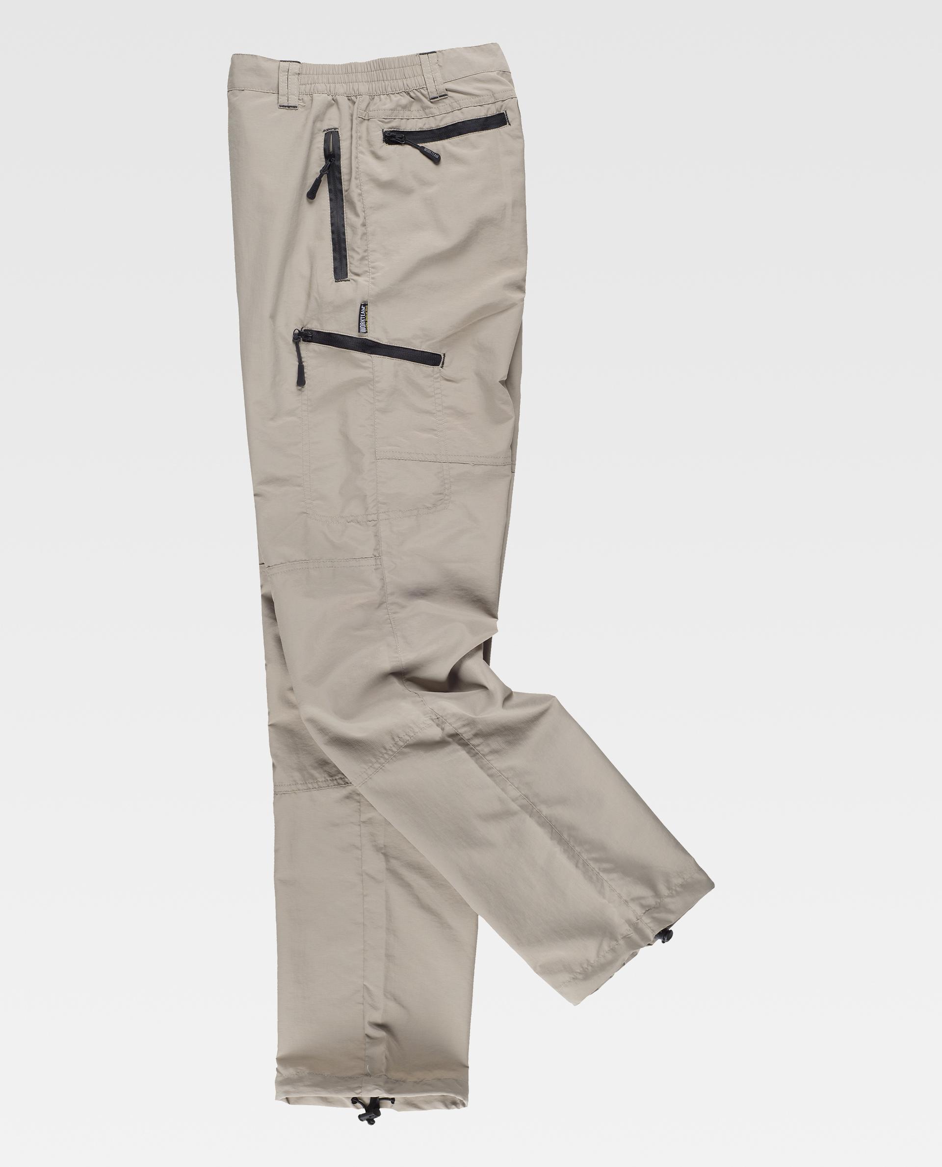 Pantalón cargo beige con cintura elástica, varios bolsillos laterales con cremallera y ajustadores en el bajo, para actividades al aire libre.