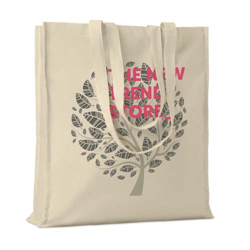 bolsa de tela reutilizable color beige con diseño de árbol de hojas y texto rosa en el centro