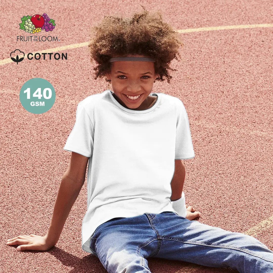 Niño sonriente con camiseta blanca Fruit of the Loom de algodón 140 GSM sentado sobre una pista de atletismo roja