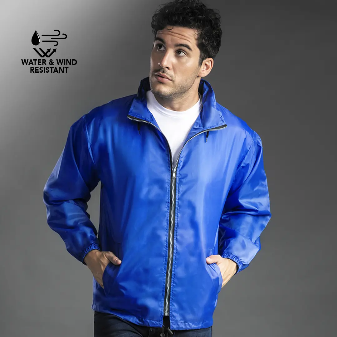 Hombre con chaqueta azul resistente al agua y al viento puesta sobre camiseta blanca