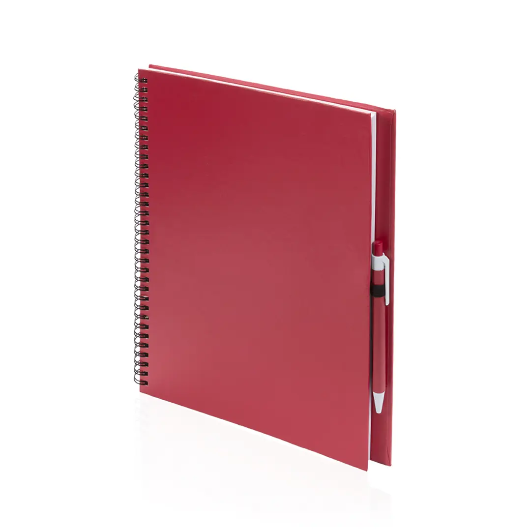 Cuaderno de tapa roja con encuadernación de espiral y bolígrafo sujeto al lomo.