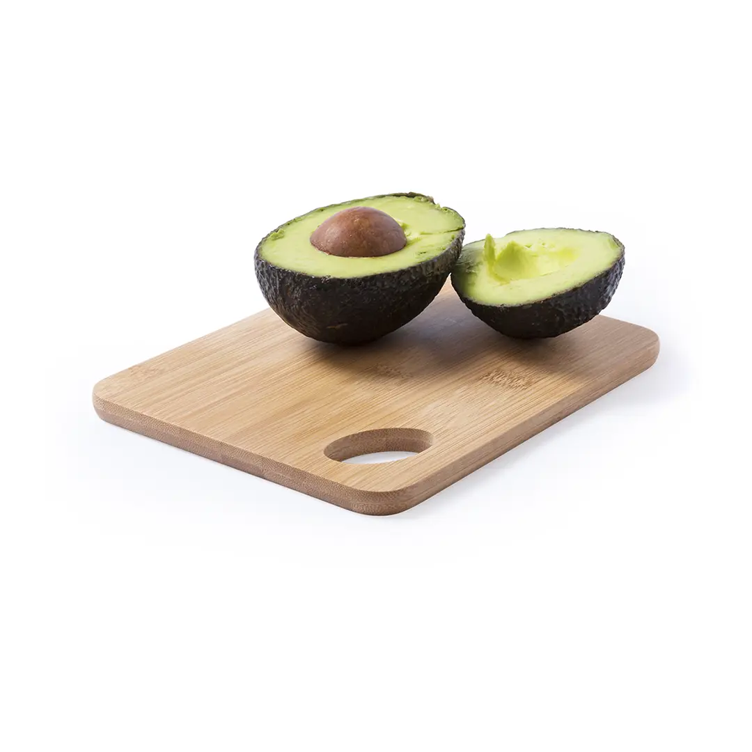 Medio aguacate con hueso y medio sin hueso sobre tabla de bambú.