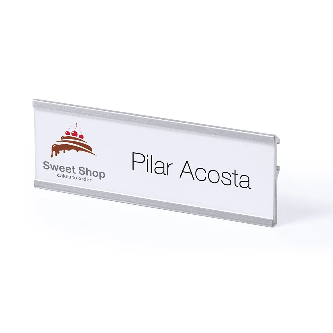 Placa de identificación blanca con el logotipo de Sweet Shop y el nombre Pilar Acosta
