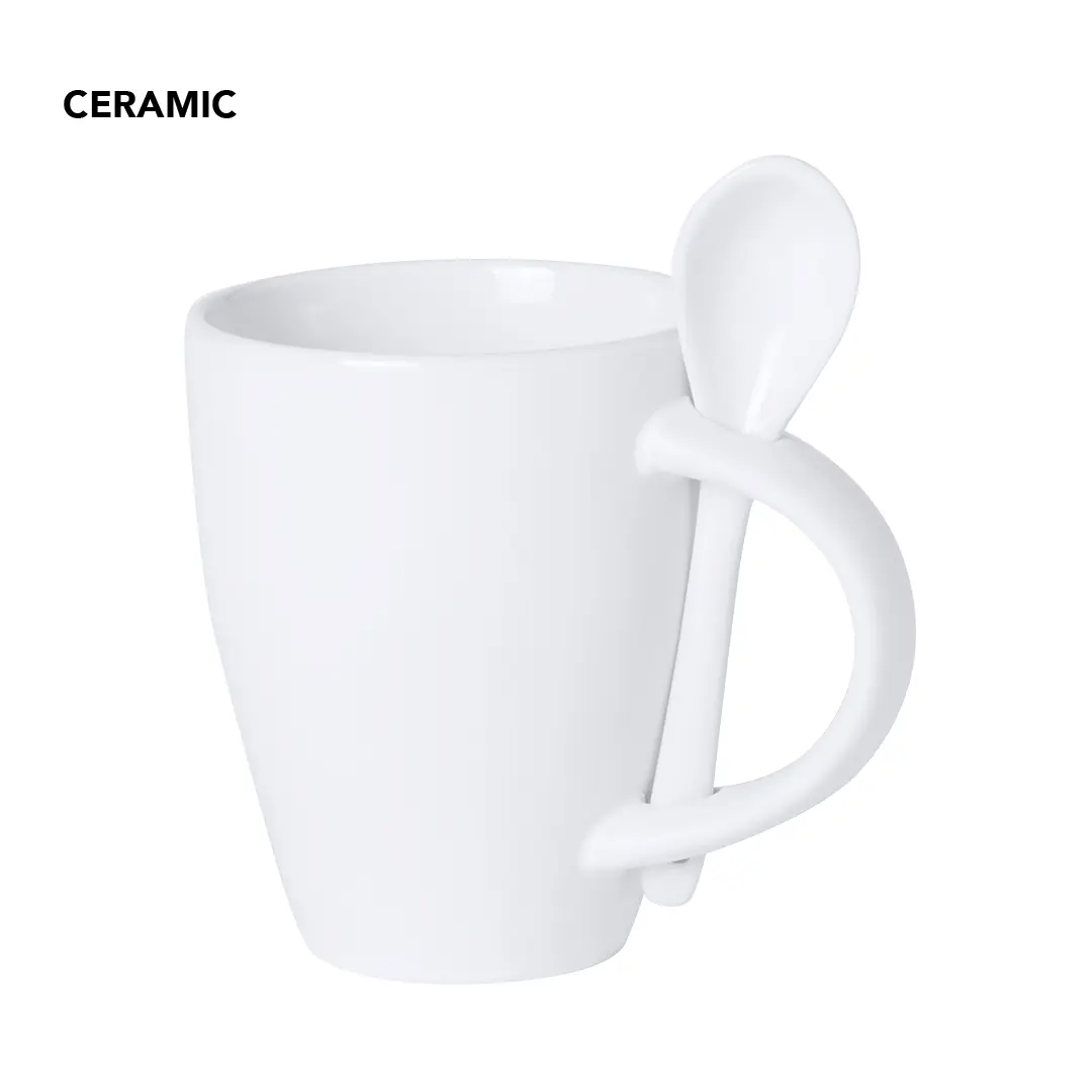 Taza de cerámica blanca con cucharilla encajada en el asa sobre fondo blanco.