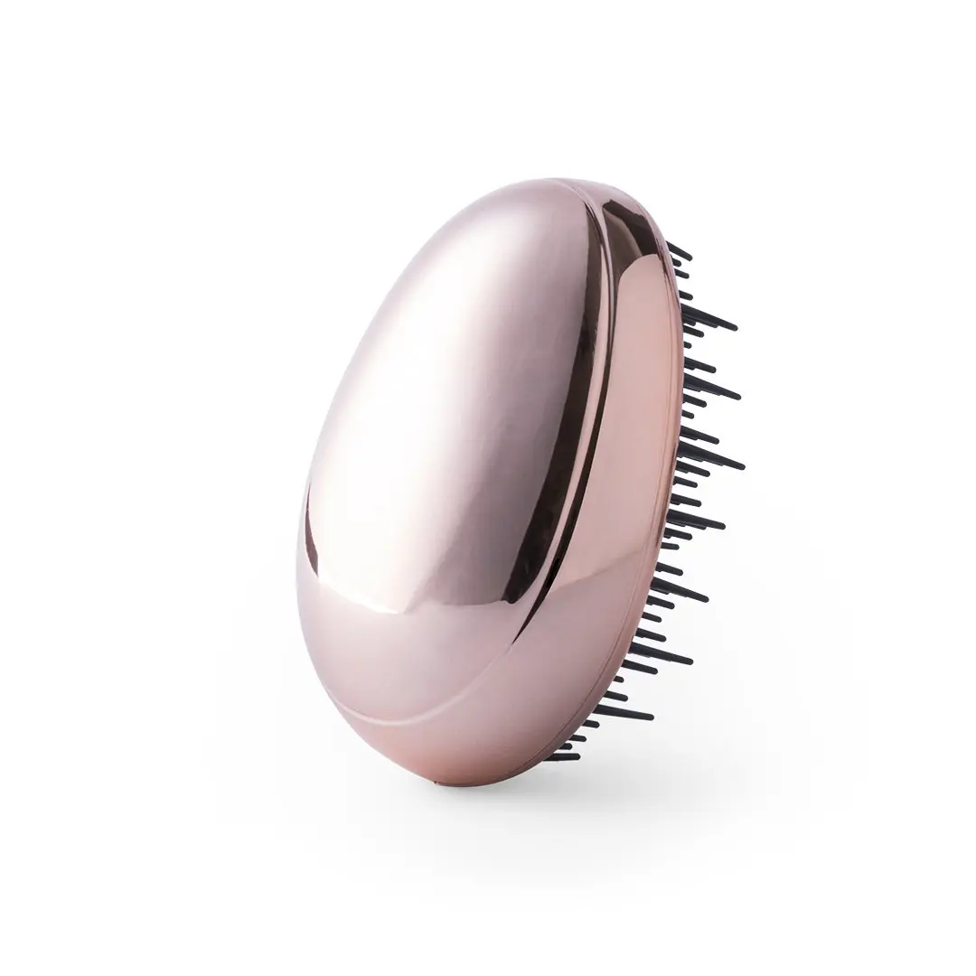 cepillo desenredante ovalado de color rosa dorado con cerdas flexibles sobre fondo blanco