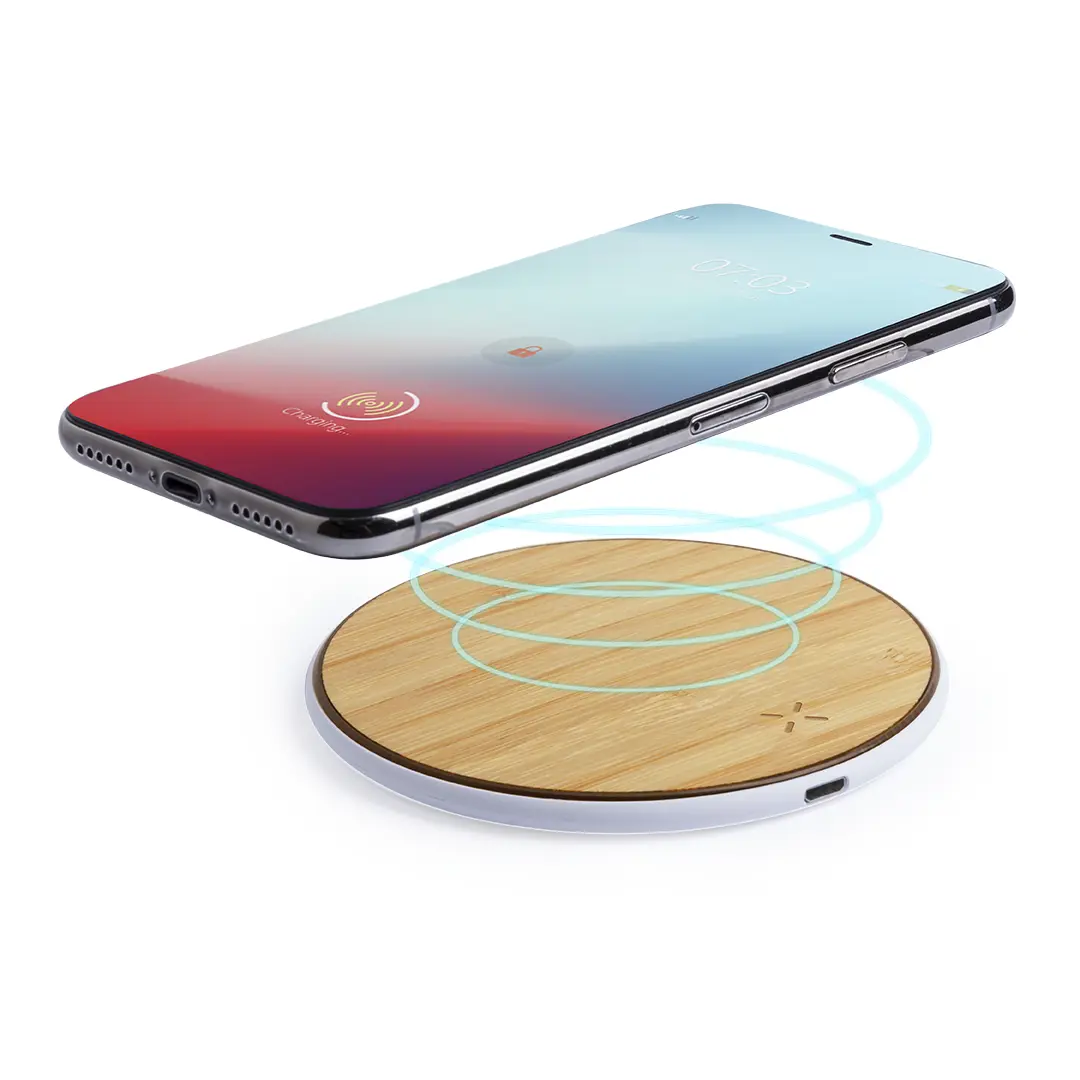 Teléfono móvil apoyado sobre una base de carga inalámbrica de bambú.