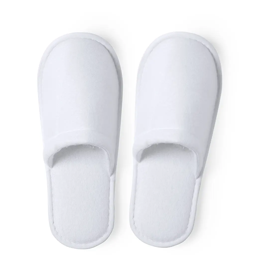 Par de zapatillas desechables blancas de estilo hotelero sobre fondo blanco.