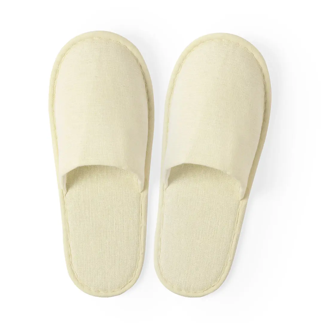 par de zapatillas de casa beige de tela sobre fondo blanco