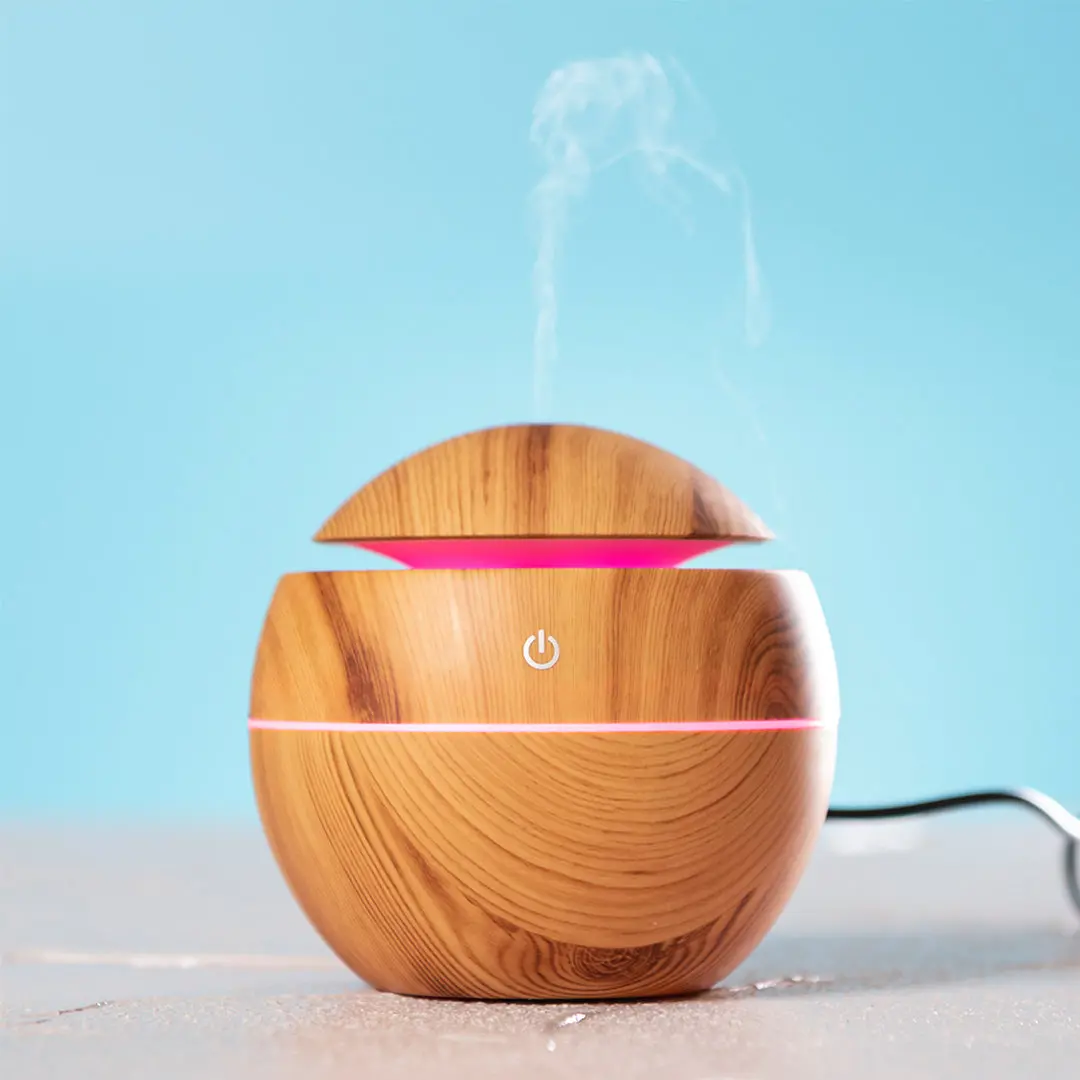 difusor de aromas de madera con luz LED rosa emitiendo vapor