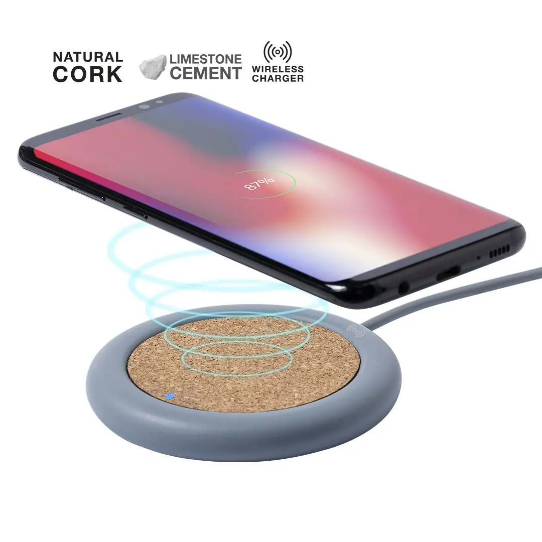 smartphone cargando de forma inalámbrica sobre base redonda con superficie de corcho natural y borde gris de cemento