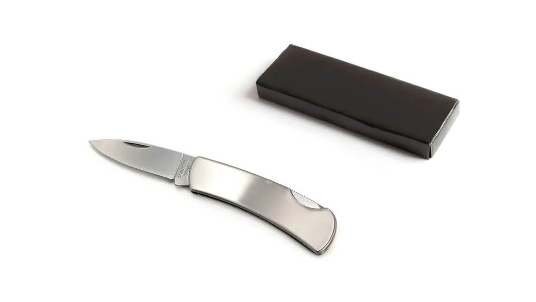 Navaja plegable de acero inoxidable junto a su estuche rectangular negro.