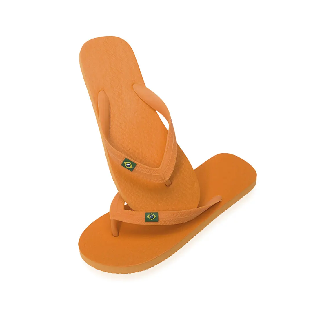 Chanclas naranjas Havaianas con bandera de Brasil sobre fondo blanco