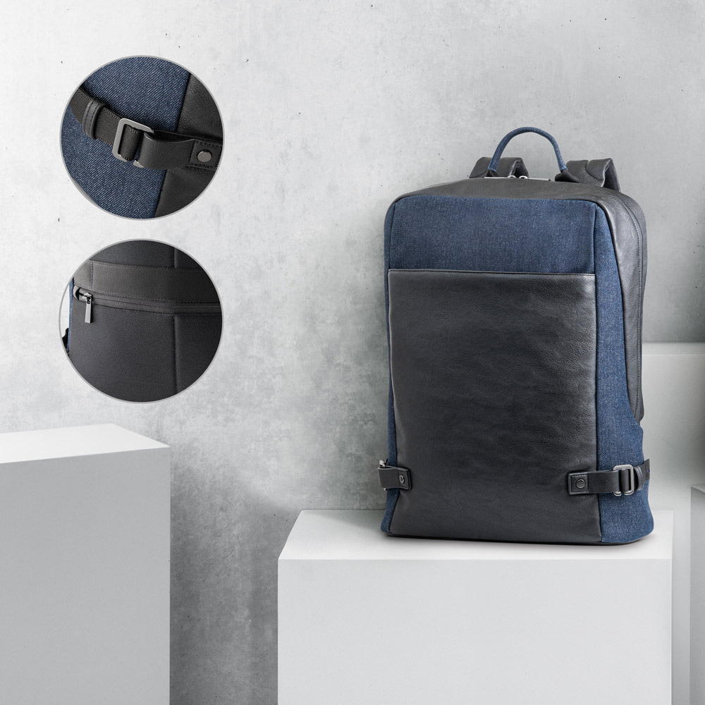 mochila urbana azul y negra con bolsillo frontal de piel sintética y detalles de hebilla y cremallera