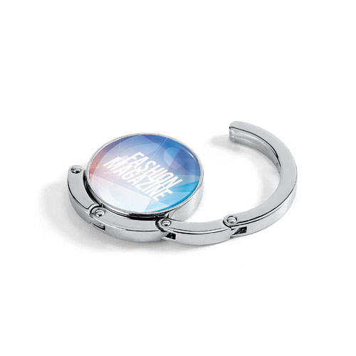 gancho metálico plegable para bolso con logo Fashion Magazine sobre fondo blanco