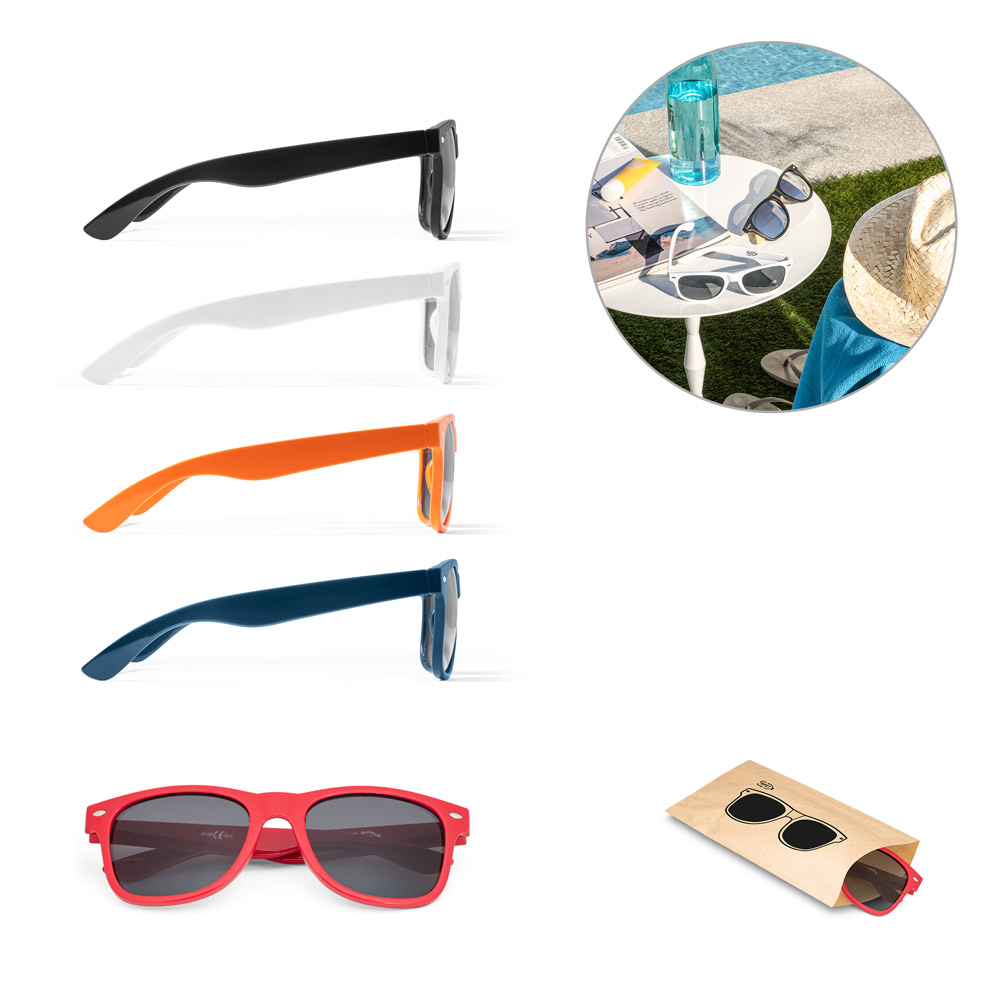 Gafas de sol de varios colores (negro, blanco, naranja, azul y rojo) mostradas de perfil junto a una mesa con accesorios de verano junto a la piscina