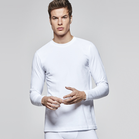Hombre posando con camiseta interior térmica blanca de manga larga sobre fondo neutro