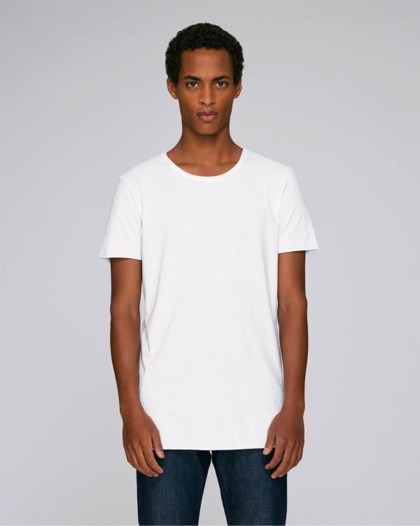 Hombre joven de pie con camiseta blanca básica y vaqueros sobre fondo gris claro