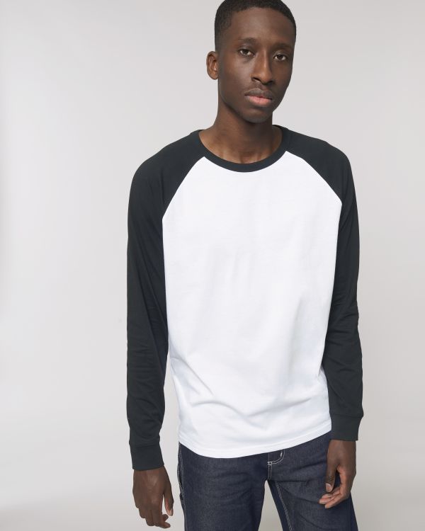 Hombre joven con camiseta de manga larga blanca y negra sobre fondo neutro