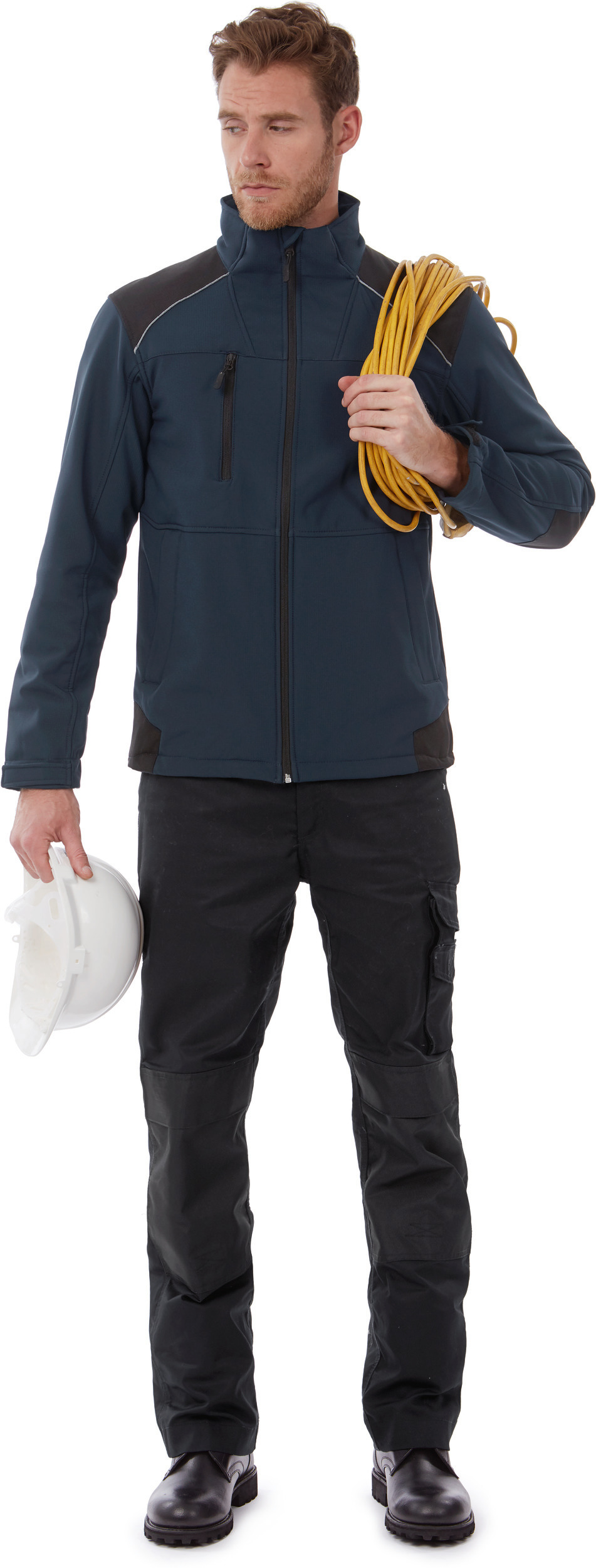 Hombre con chaqueta de trabajo azul y pantalones negros sosteniendo un casco blanco y un cable amarillo enrollado sobre el hombro