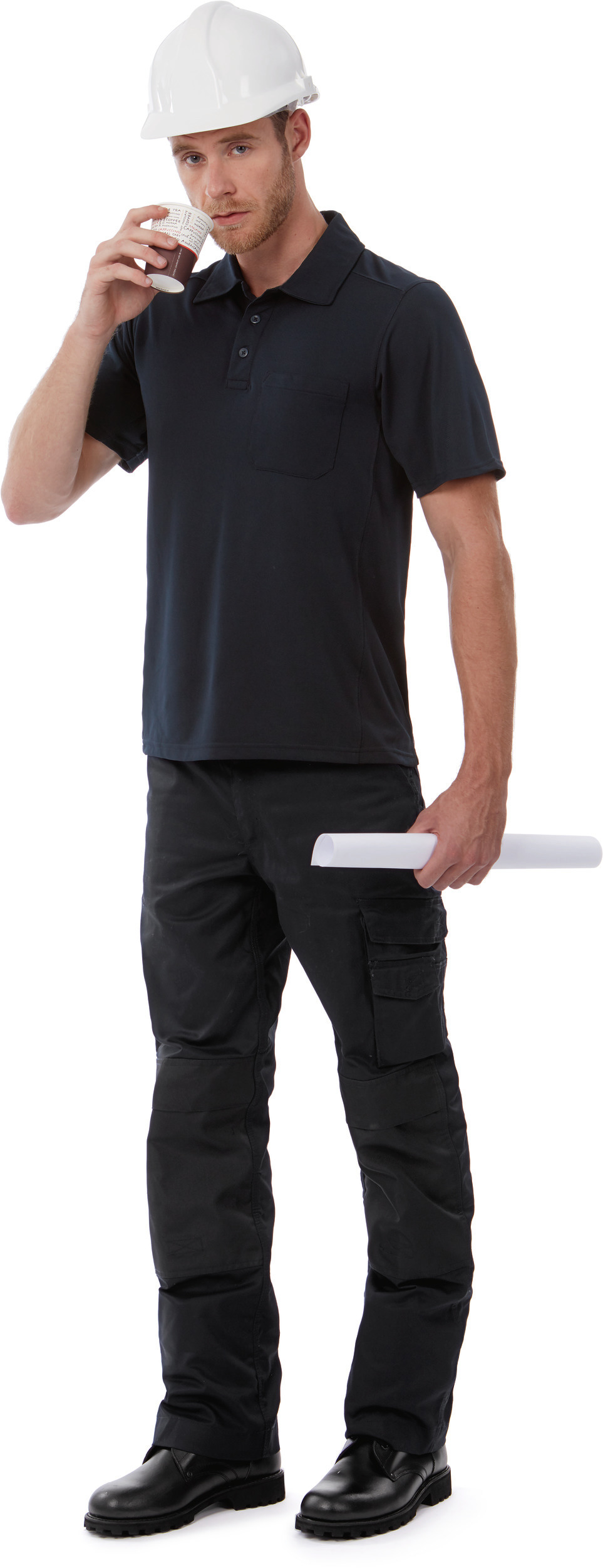 obrero con casco blanco, polo oscuro y pantalones de trabajo bebiendo café mientras sostiene un plano enrollado