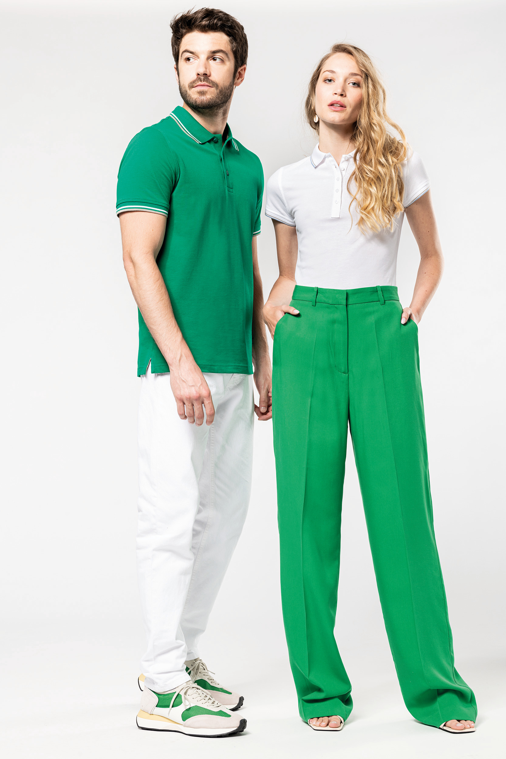 hombre y mujer posando con ropa informal verde y blanca sobre fondo neutro