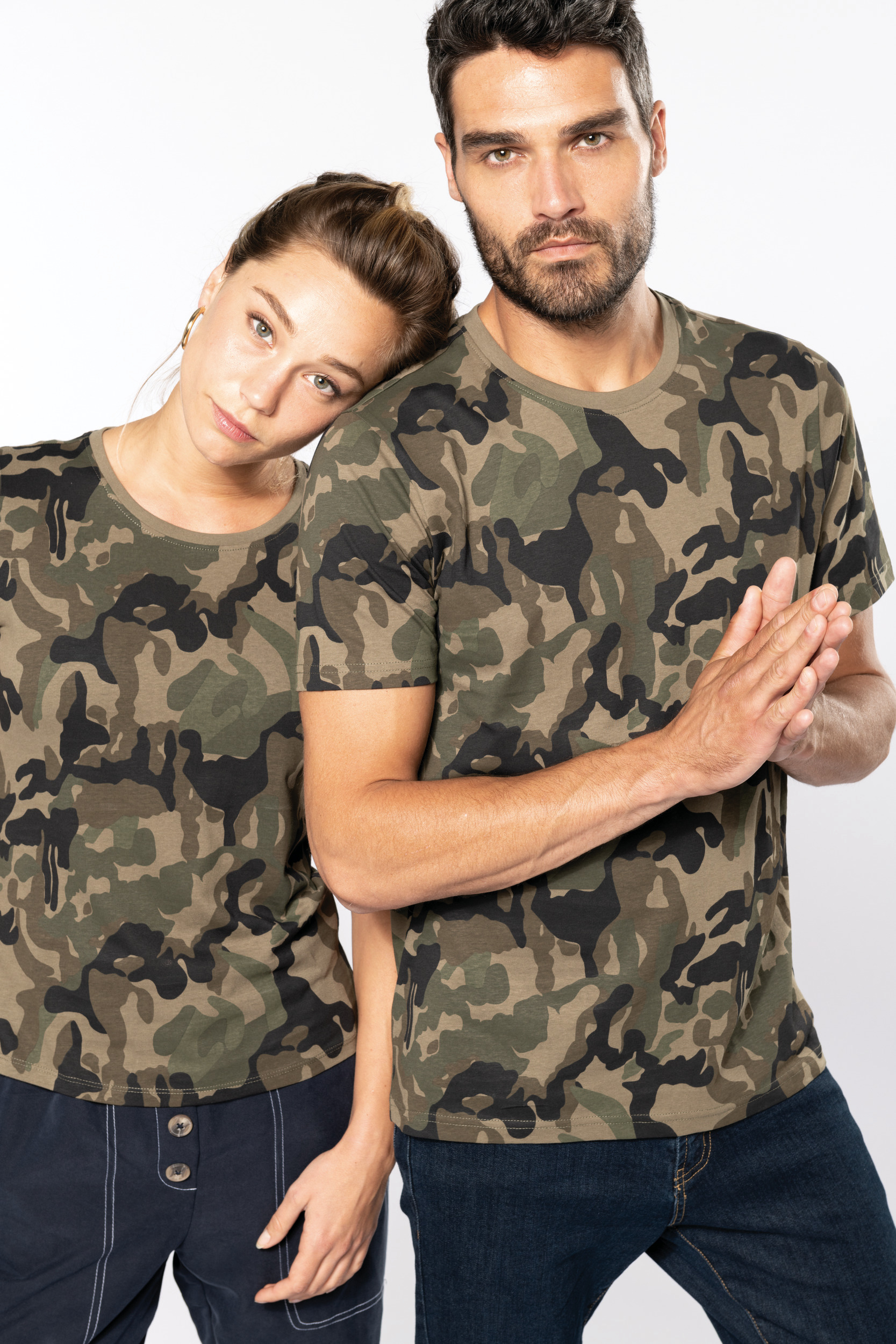 pareja de modelos con camisetas de camuflaje posando en estudio