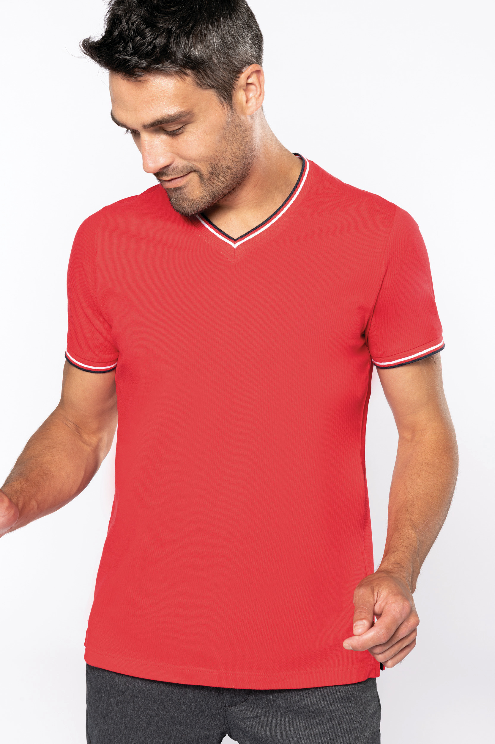 Hombre con camiseta roja de cuello de pico y ribete tricolor looking down.