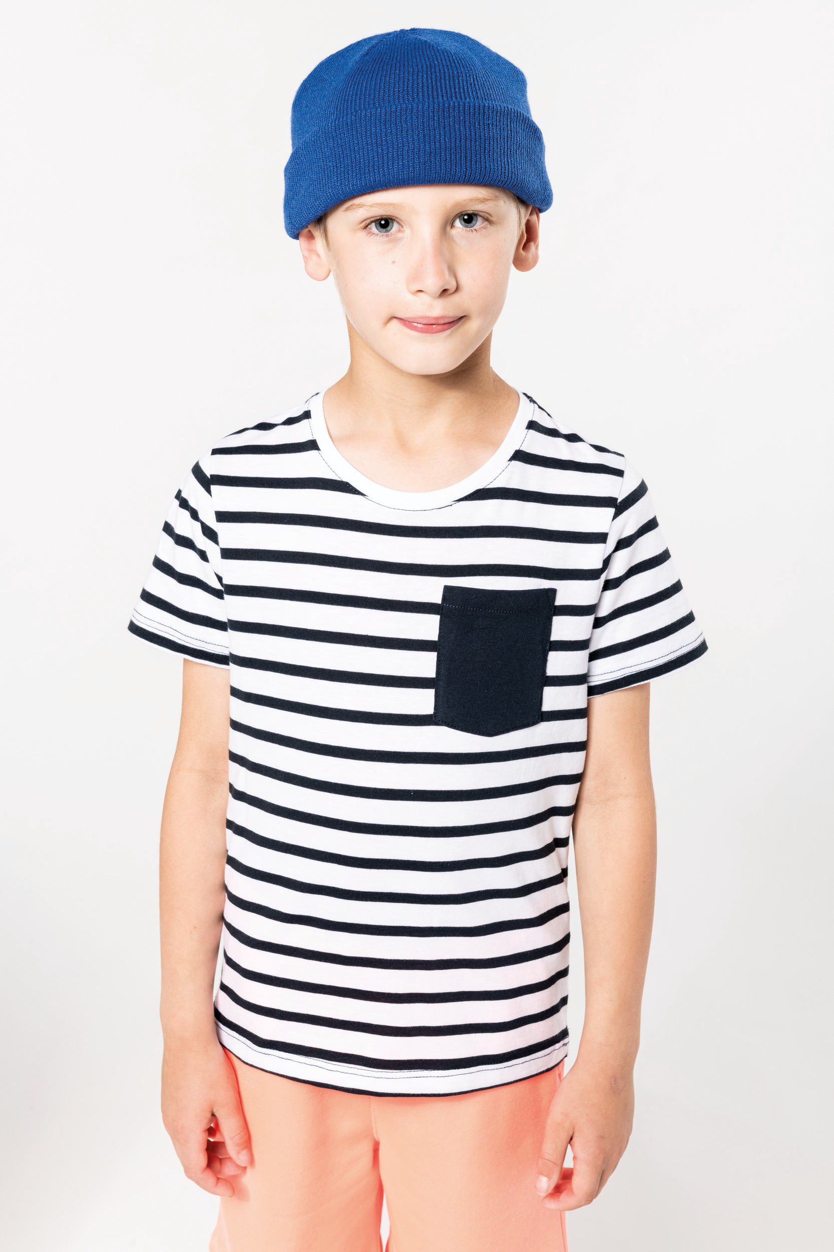 Niño con camiseta de rayas negras y blancas y gorro azul sobre fondo blanco