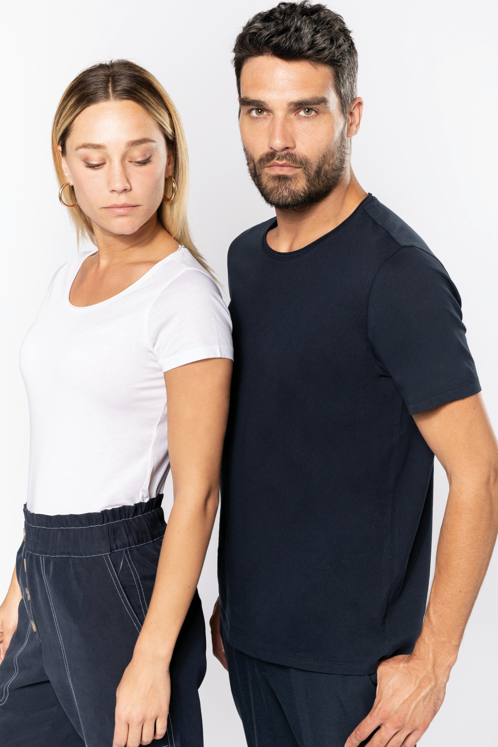dos modelos de pie uno al lado del otro con camiseta blanca y azul marino sobre fondo neutro