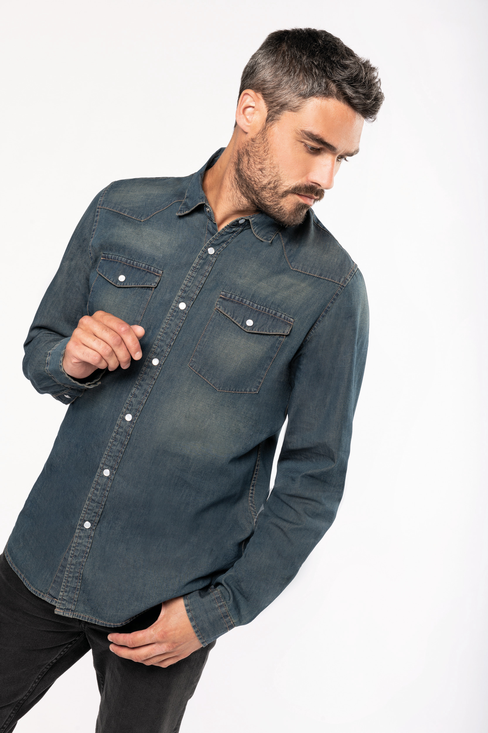 hombre moreno con barba y camiseta vaquera azul de botones sobre fondo blanco