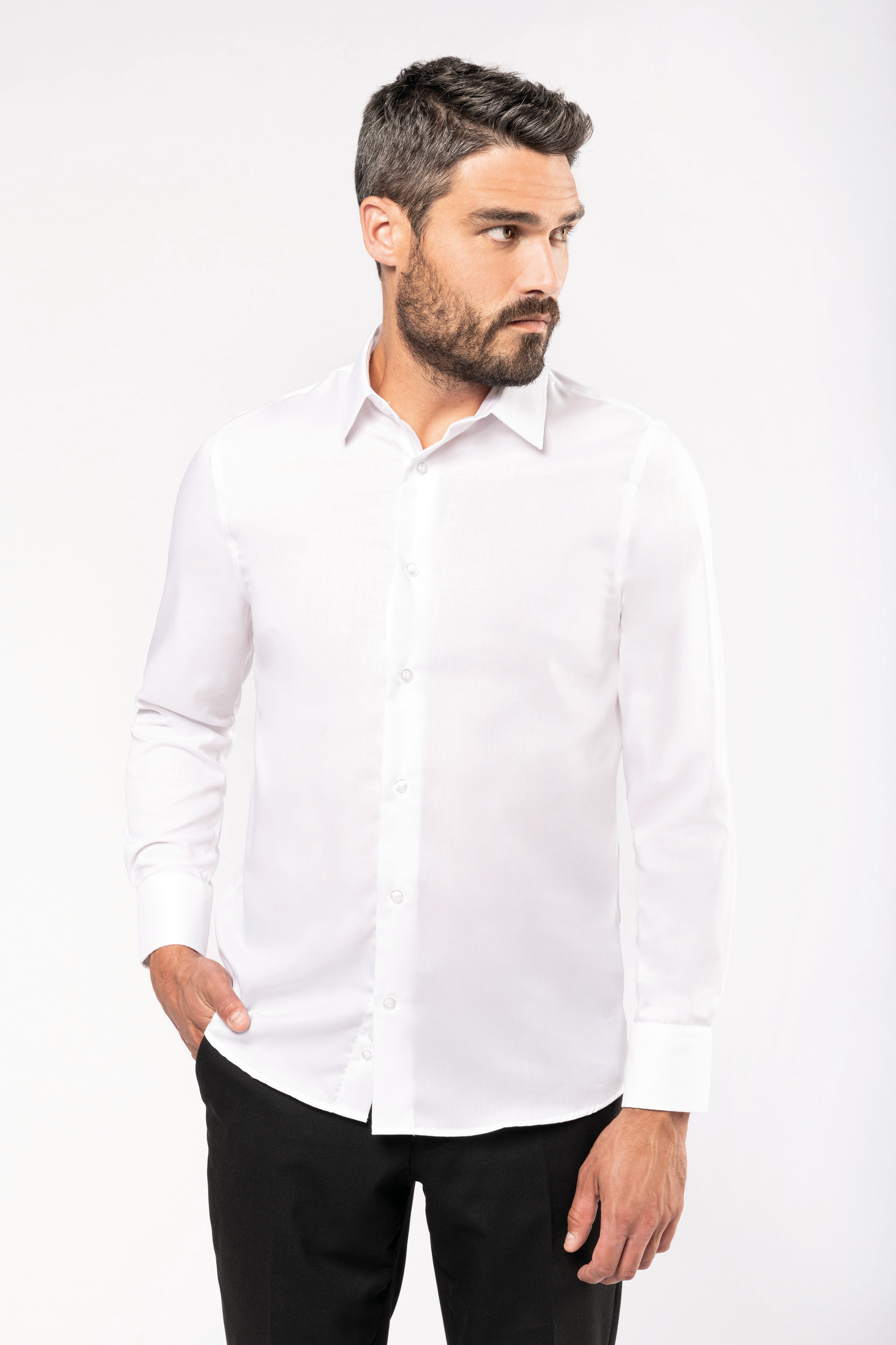 Modelo masculino con camisa blanca de manga larga y pantalón negro sobre fondo blanco.