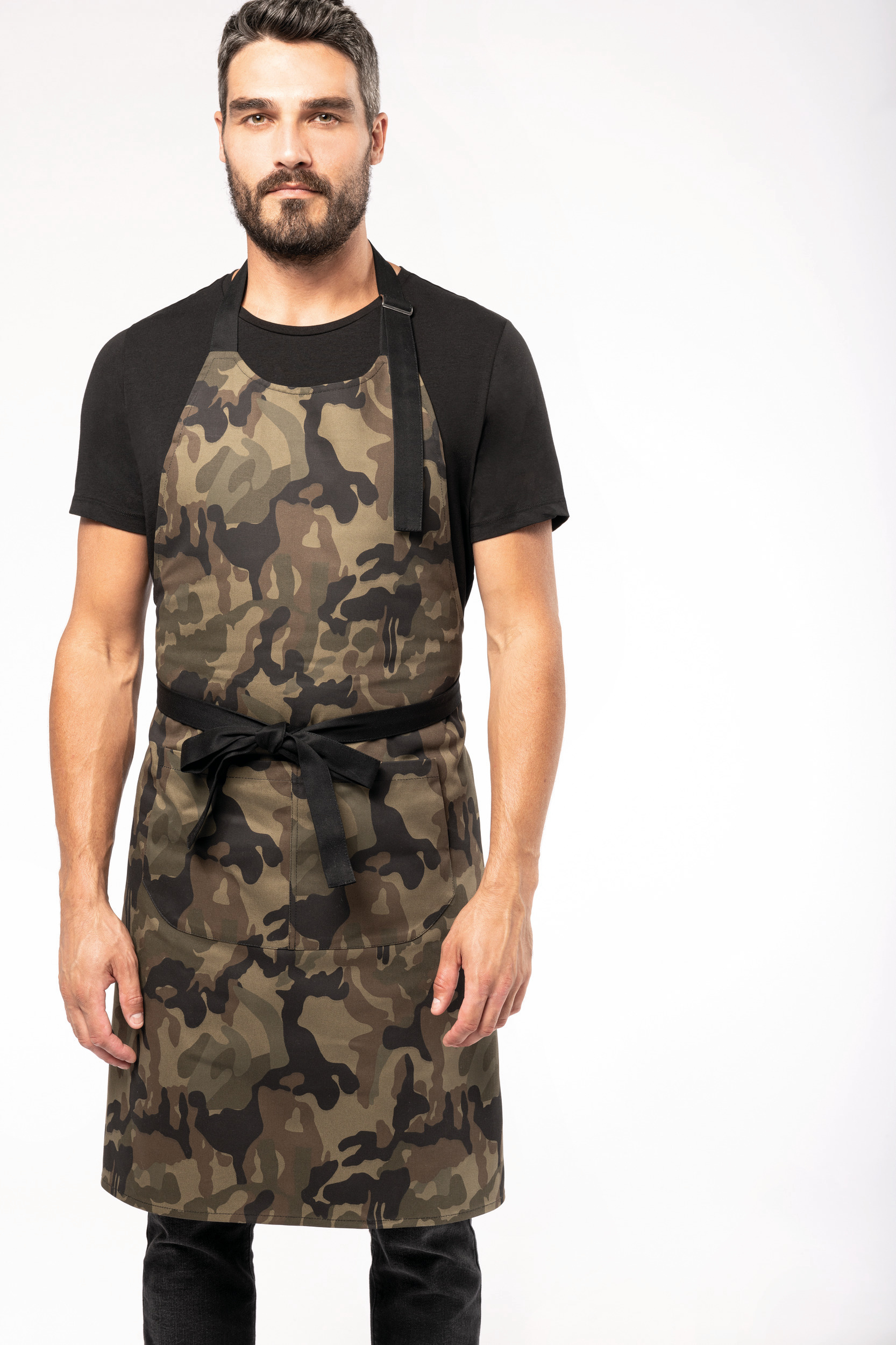 Hombre con camiseta negra y delantal de camuflaje atado a la cintura sobre fondo blanco