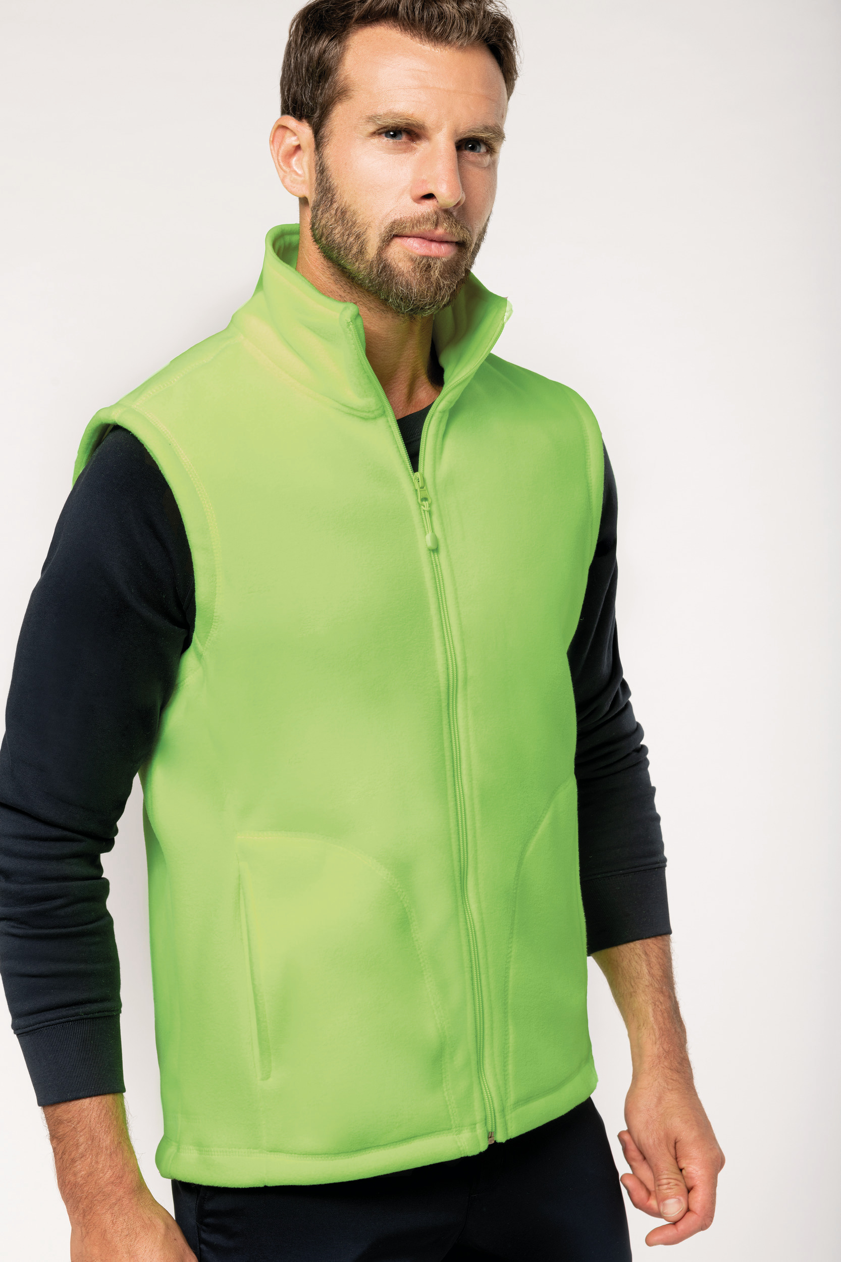 hombre con chaleco polar verde lima de cremallera sobre camiseta negra