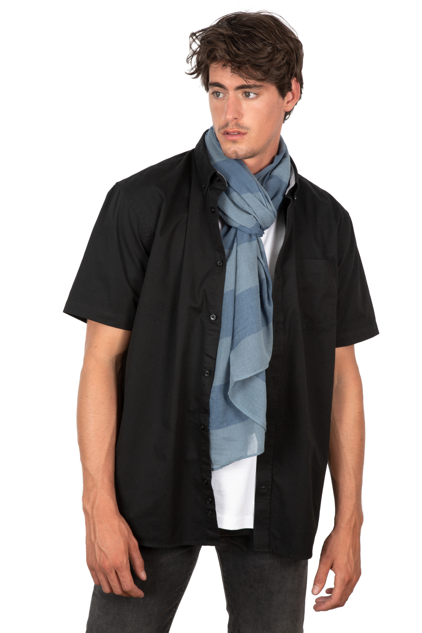 Hombre joven con camisa negra de manga corta sobre camiseta blanca y bufanda azul claro sobre fondo blanco