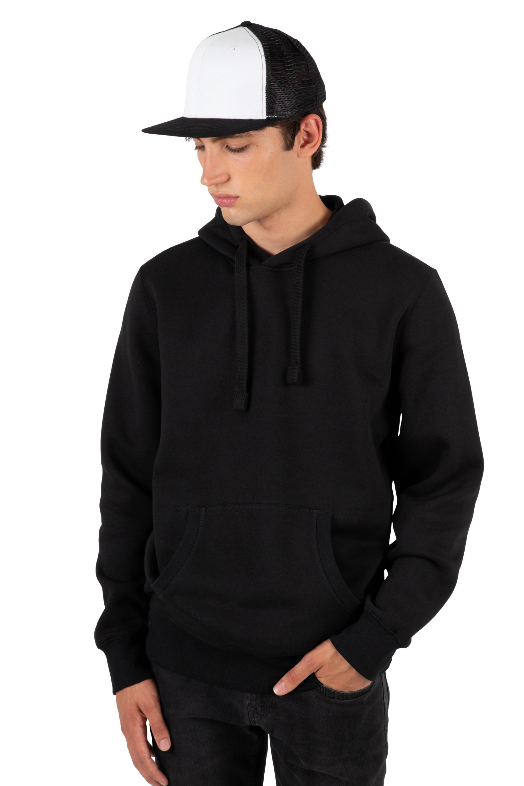 Hombre joven con sudadera negra con capucha y gorra trucker bicolor sobre fondo blanco.