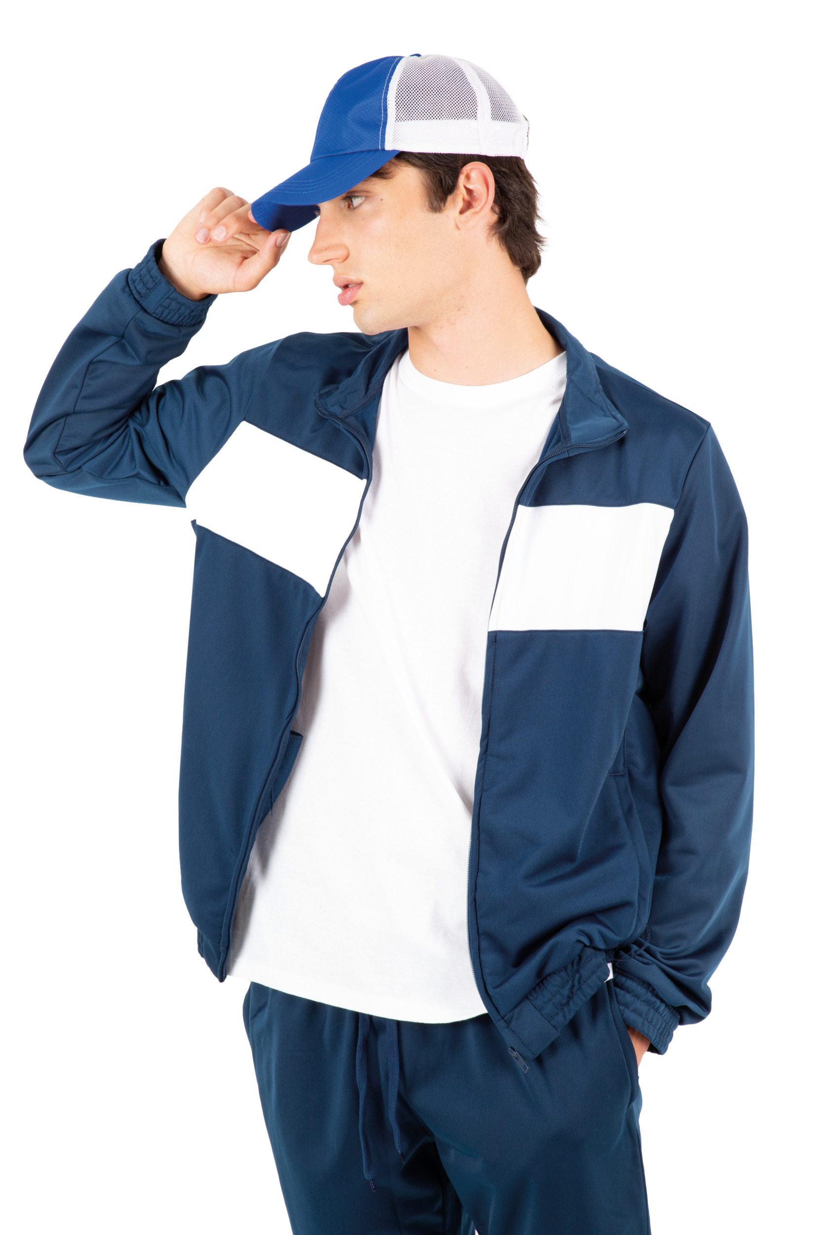 Modelo masculino con chándal azul de franjas blancas y gorra de rejilla sobre fondo blanco