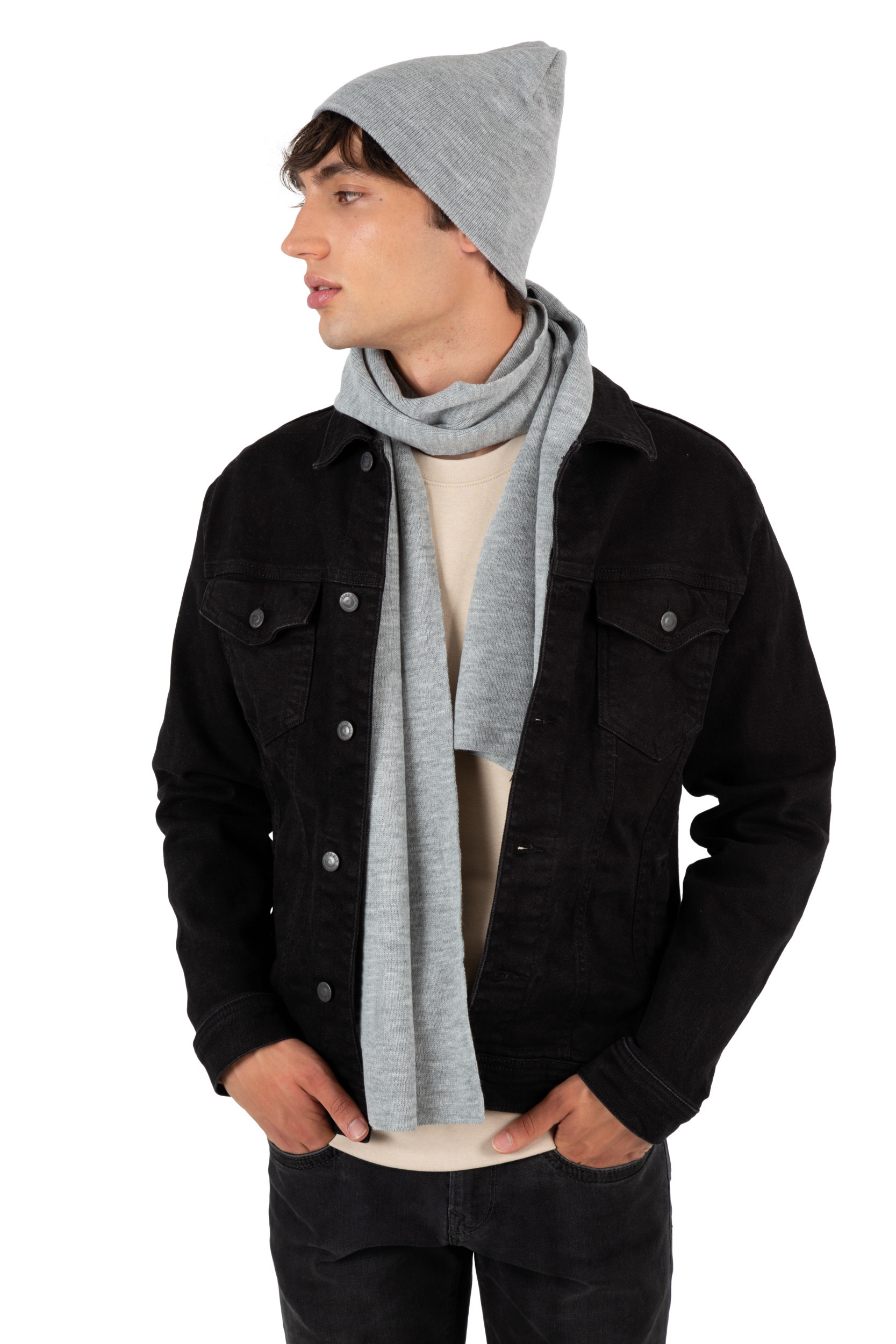 Hombre con chaqueta vaquera negra, gorro de punto gris y bufanda gris sobre fondo blanco