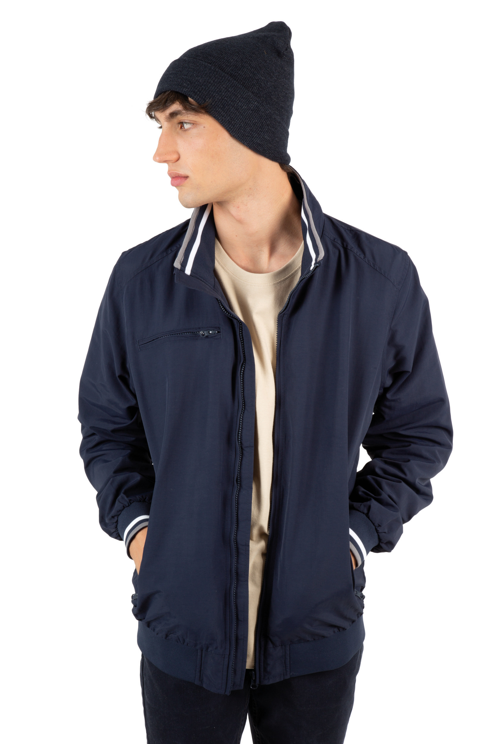 Joven con chaqueta azul marino y gorro de punto en fondo blanco.