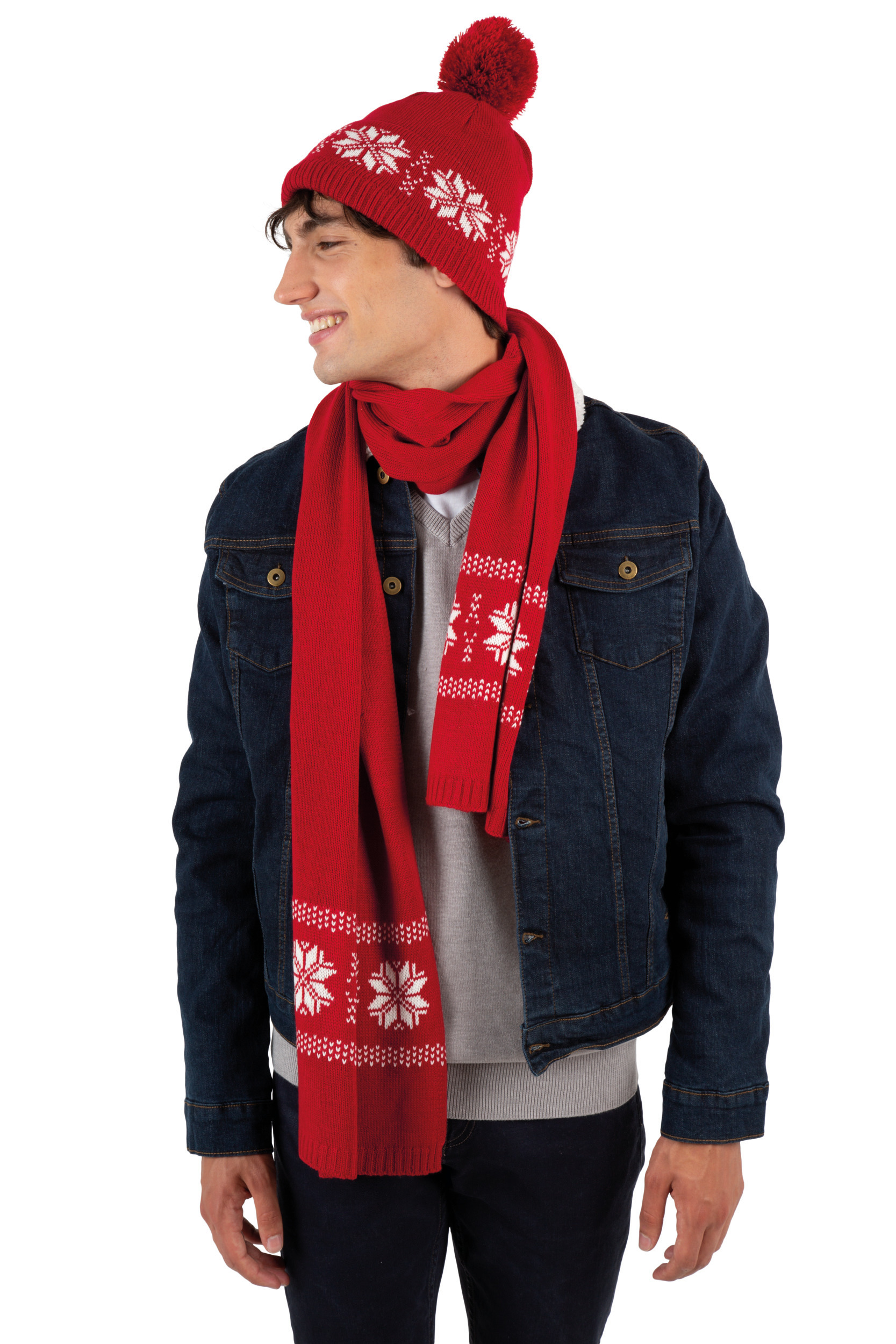 Hombre joven con gorro y bufanda rojos de estampado invernal y cazadora vaquera sobre fondo blanco.