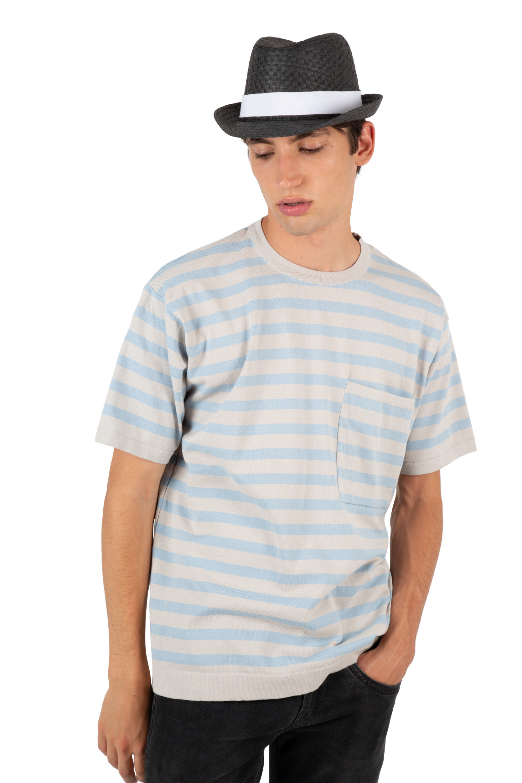 hombre joven con camiseta de rayas azules y blancas y sombrero de paja negro sobre fondo blanco