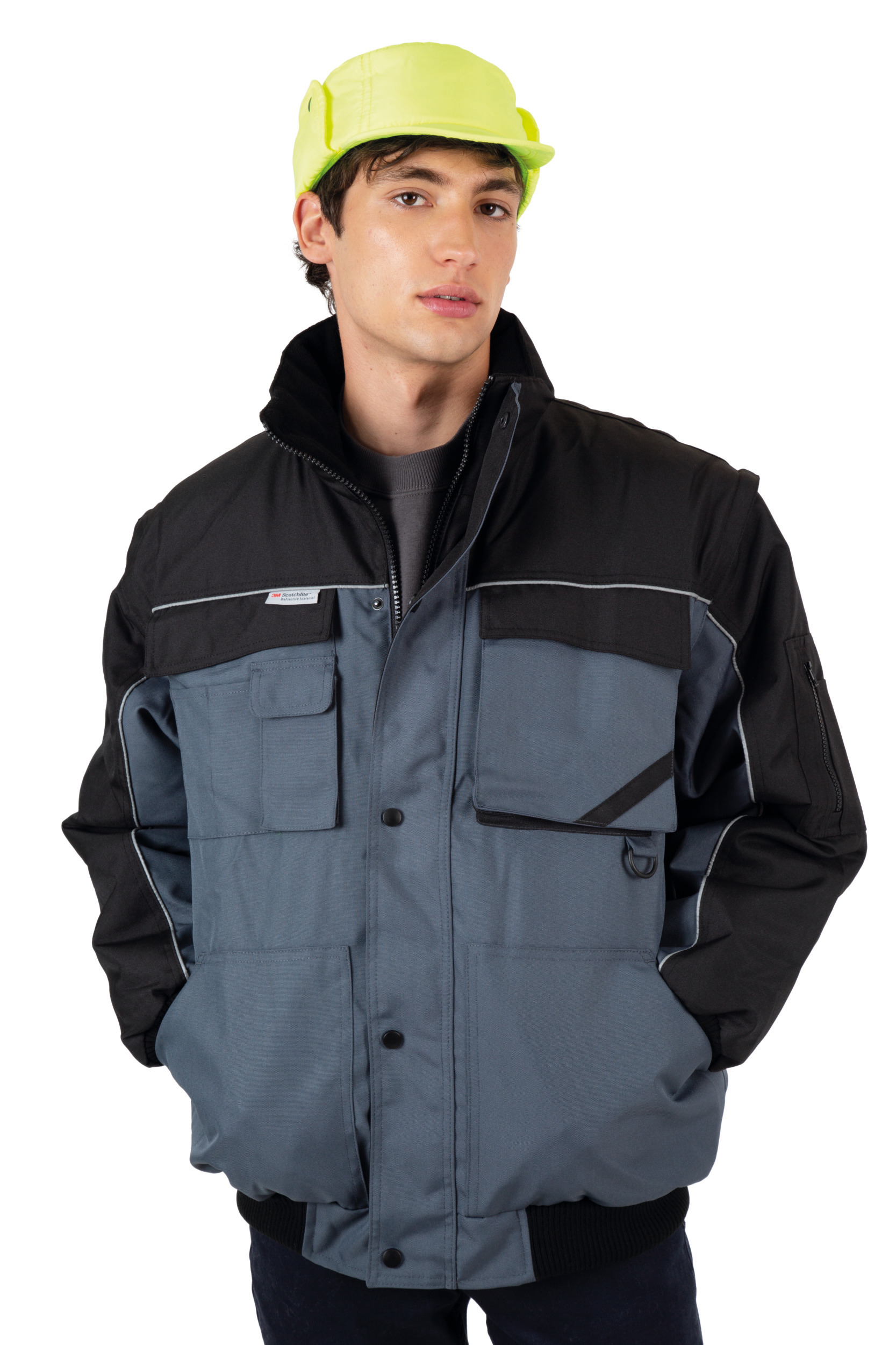 Hombre con chaqueta de trabajo acolchada gris y negra y gorra de seguridad amarilla.
