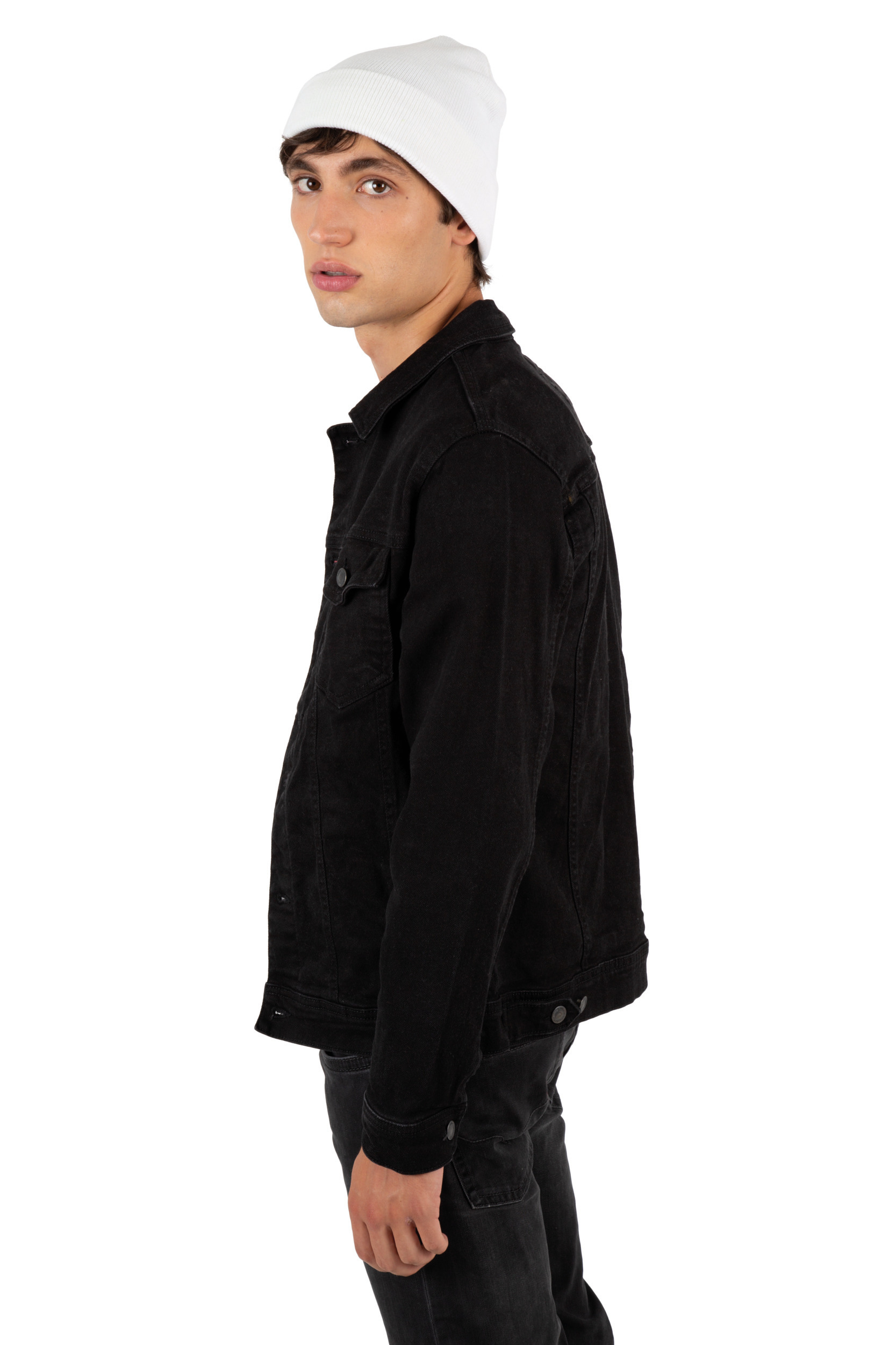 Modelo masculino con gorro blanco y chaqueta vaquera negra sobre fondo blanco