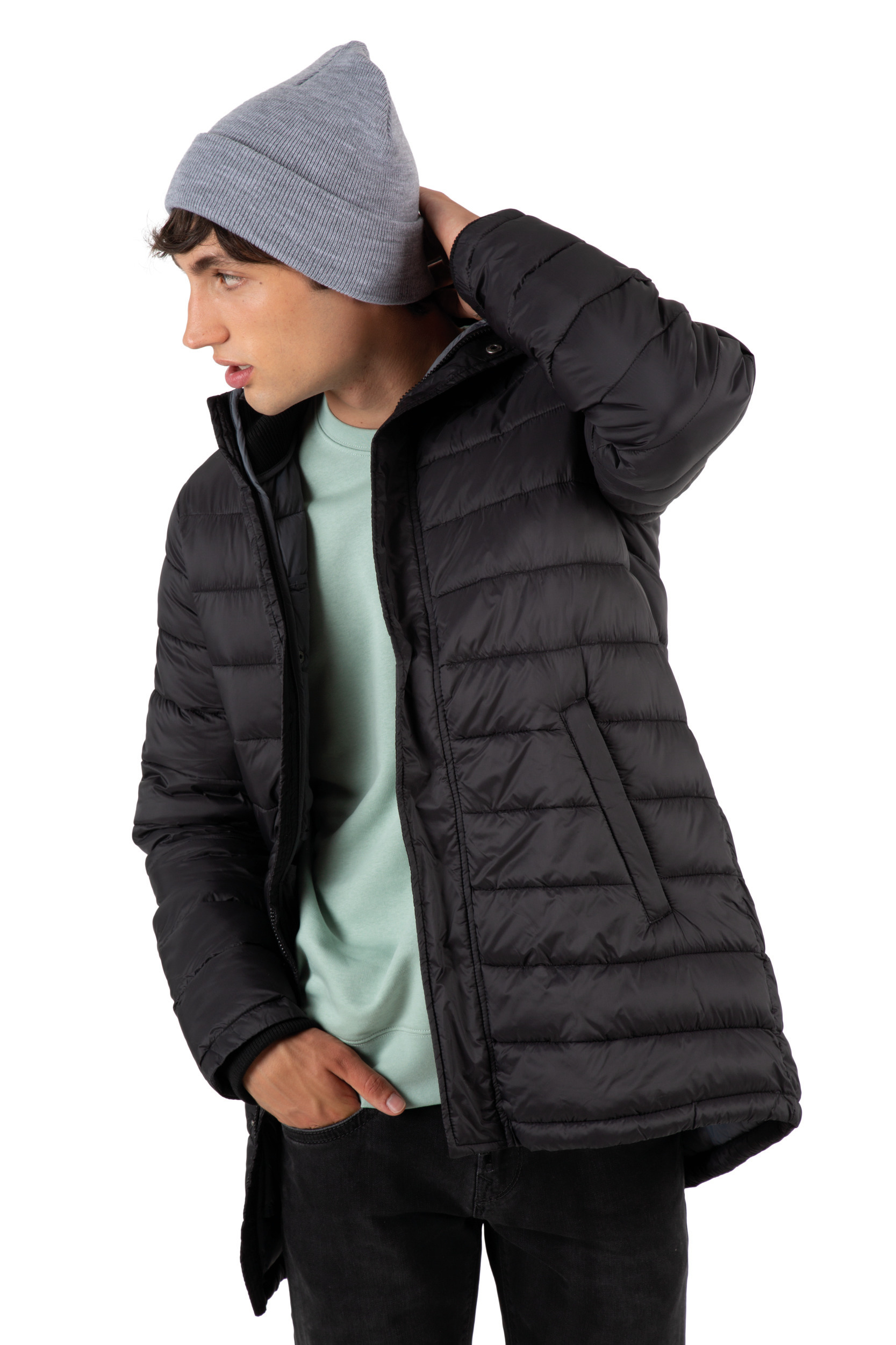 Hombre joven con gorro gris y chaqueta acolchada negra sobre fondo blanco