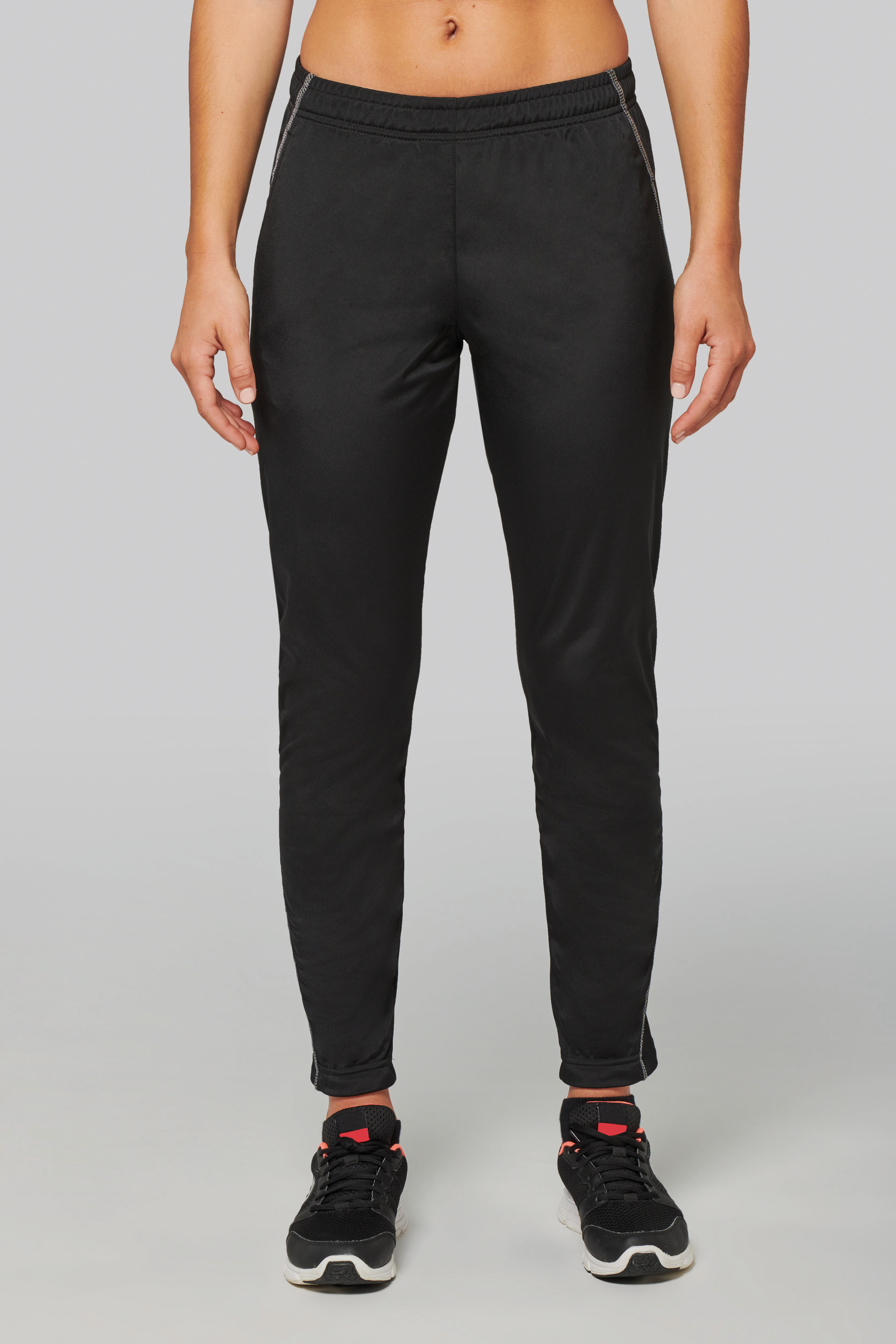 Primer plano de mujer con pantalones de chándal negros y zapatillas deportivas