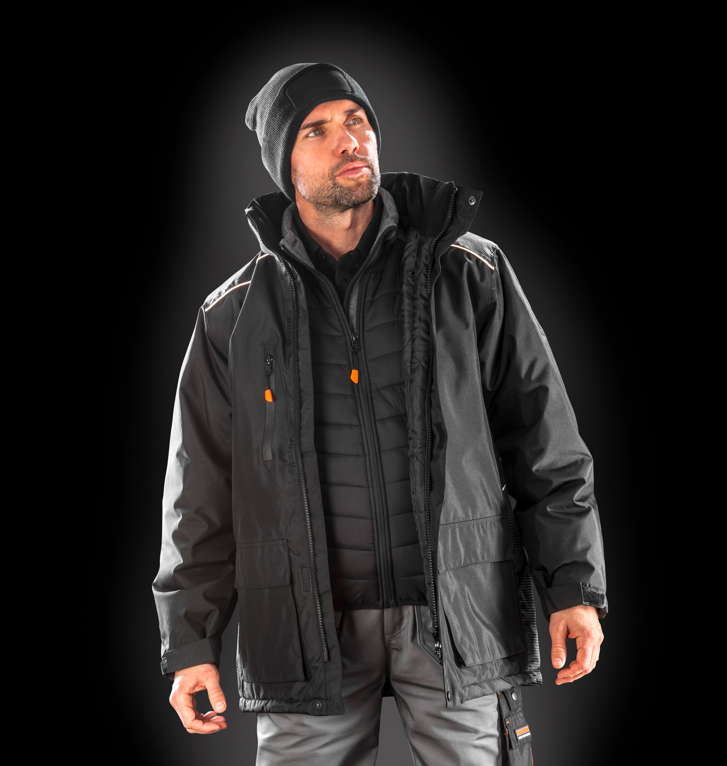 Hombre con chaqueta de invierno negra y gorro de punto sobre fondo oscuro