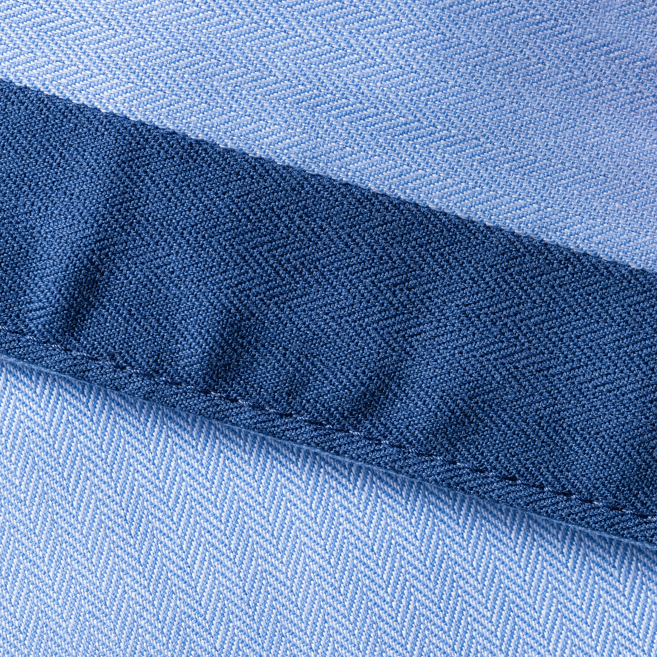 detalle de tela azul claro y azul marino con costura diagonal y patrón de espiga
