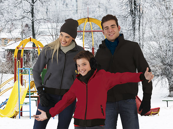 Familia con chaquetas de invierno posando en un parque infantil nevado
