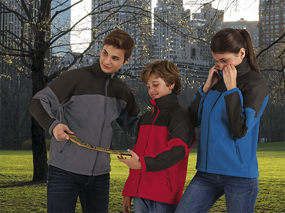 tres jóvenes con chaquetas deportivas miden distancia con una cinta métrica en un parque urbano