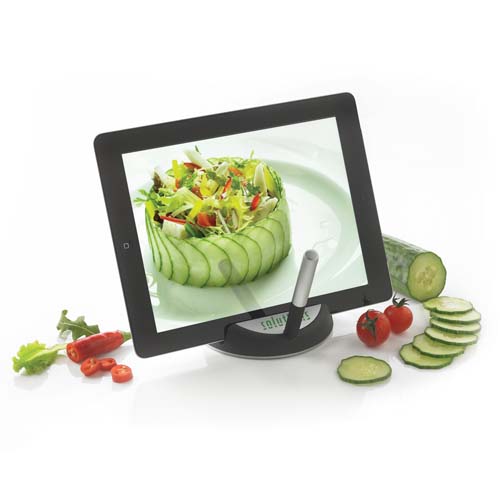 Tableta en soporte mostrando una ensalada de pepino y verduras frescas junto a tomates cherry y rodajas de pepino.